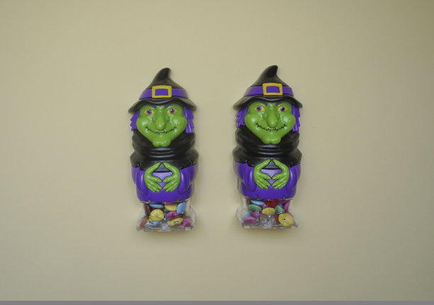 可爱的角色在怪物服装。一个可爱的女巫的可怕的万圣节人物站在一个明亮的背景特写。万圣节的概念。节日装饰品，玩具图片下载