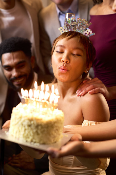 一群朋友围着钢琴用蛋糕庆祝女人的生日图片下载