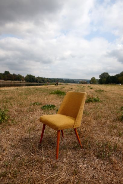 早春时节，院子里的一张黄色椅子的垂直照片图片下载