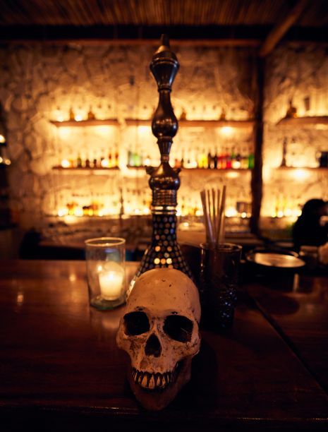 墨西哥昆塔纳罗奥图卢姆一家酒吧的柜台上垂直拍摄的一个人类头骨图片下载