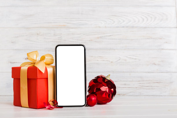 数字手机模拟与乡村圣诞装饰的应用程序演示与空白空间为您设计。圣诞网购概念。彩色背景上有复制空间的写字板图片下载
