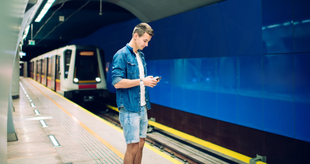 带着智能手机的时髦男子在等火车图片下载