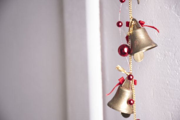 圣诞装饰的金色金属钟与红色闪亮的圣诞小玩意特写图片下载
