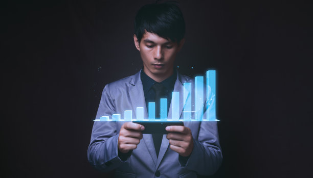 一个穿着蓝色西装的男人正在看商业图形全息图的特写。图片下载