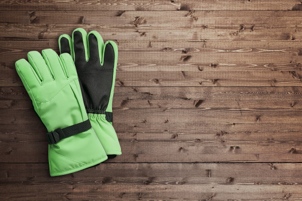 木制背景的绿色冬季手套图片下载