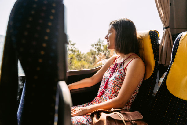 年轻女子在公共汽车上向窗外看图片下载