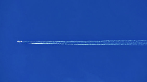 蓝天背景下的飞机凝结尾迹的风景图片下载