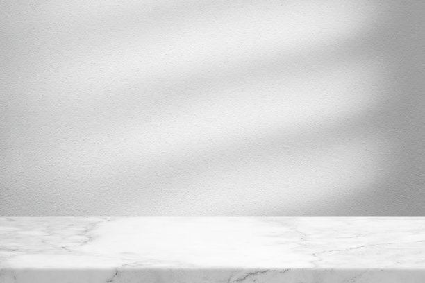 大理石桌子与白色混凝土墙纹理背景与光束和阴影，适合产品展示背景，展示，和模拟。图片下载