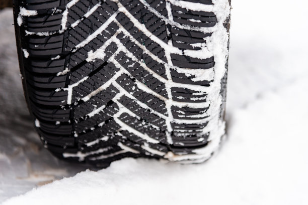 冬天积雪路面上汽车轮胎的胎面细节。冬天路上的汽车轮胎被雪覆盖。冬季轮胎。冬天被雪覆盖的道路上汽车轮胎的细节。特写。图片下载