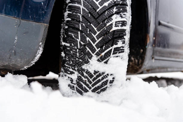 冬天路上的汽车轮胎被雪覆盖。雪道上的车辆。冬季轮胎。冬天被雪覆盖的道路上汽车轮胎的细节。图片下载