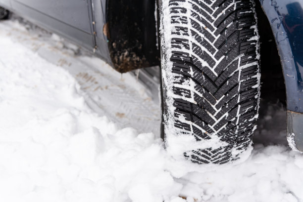 冬天路上的汽车轮胎被雪覆盖。雪道上的车辆。冬季轮胎。冬天被雪覆盖的道路上汽车轮胎的细节。图片下载