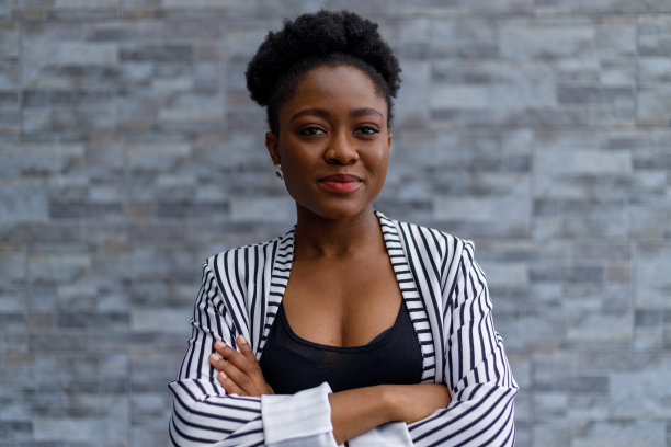 自信的企业家双臂交叉靠墙站着图片下载