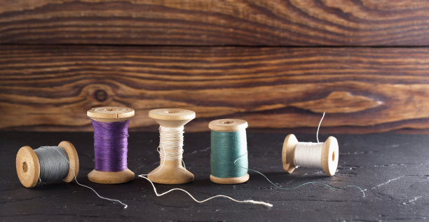 旧木线轴上的缝纫线白色，绿色图片下载