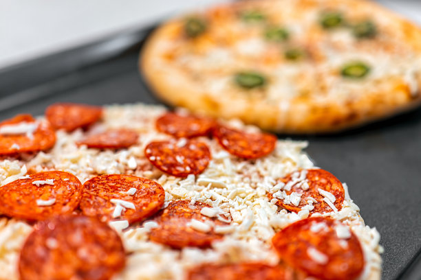 微观特写未煮生的采取和烘烤冷冻意大利辣香肠切碎的马苏里拉奶酪和墨西哥辣椒披萨派在托盘上准备烘烤烹饪在厨房桌子上的背景图片下载