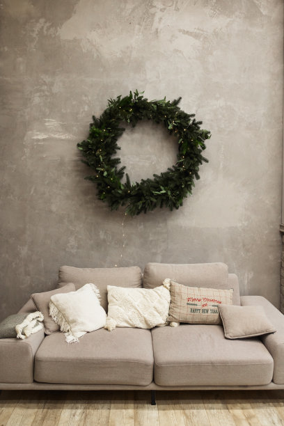 现代客厅内部灰色沙发和圣诞花环在墙上图片下载