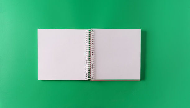 一个空白的A4笔记本在绿色纸背景上展开形式，俯视图，模型。图片下载