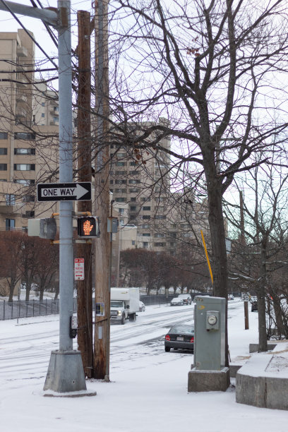 一个寒冷的下午，在一场雪后的街角和汽车在一起。图片下载