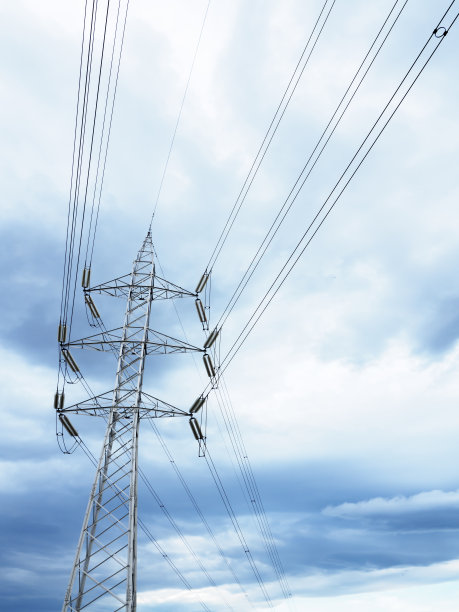 高压电塔顶着乌云密布的天空，能源和经济的概念图片下载