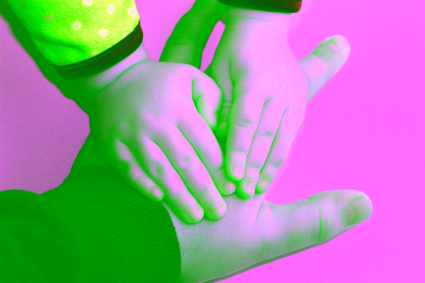 小孩子的手把大人的大手按在白色的表面上图片下载