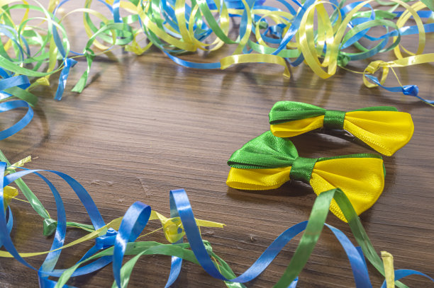 木制桌子上有巴西色的领结，上面有绿色、黄色和蓝色的丝带图片下载