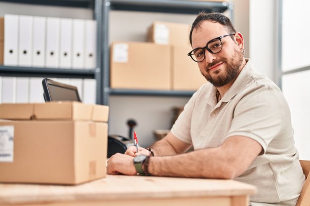 年轻的西班牙人电子商务工作人员在办公室的笔记本上写图片下载
