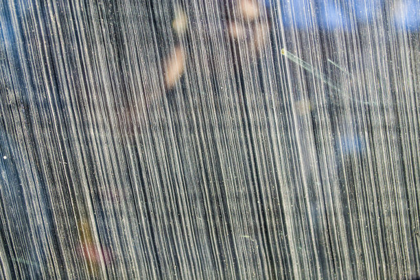 黑色背景玻璃上有白色划痕和斑点。图片下载