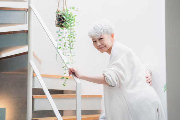 上了年纪的妇女在楼梯上背痛图片下载
