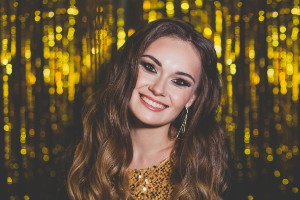 美丽的女性名人化妆在金色的散景背景图片下载