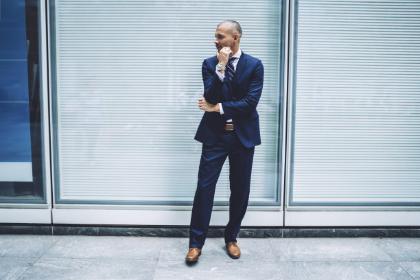 站在现代城市街头的有思想的企业家图片下载