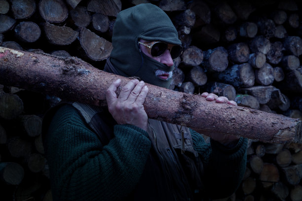 一个人晚上在森林里偷柴火。图片下载