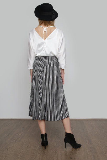 系列工作室照片迷人的年轻女模特穿着优雅的白色丝绸缎衬衫和提花中长裙。图片下载