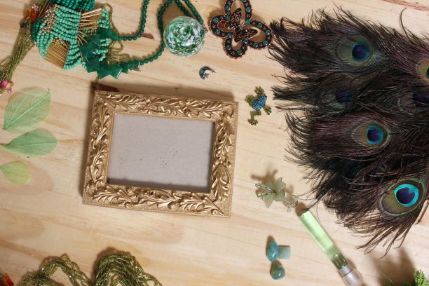 绿色珠宝和孔雀羽毛与黄金相框木桌图片下载