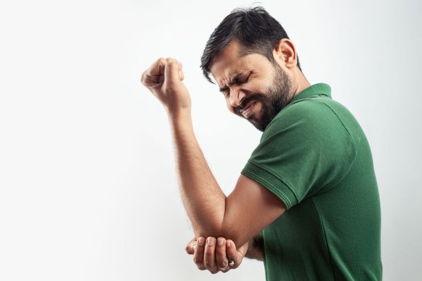 一人显示肘部受伤疼痛概念，面部表情扭曲图片下载