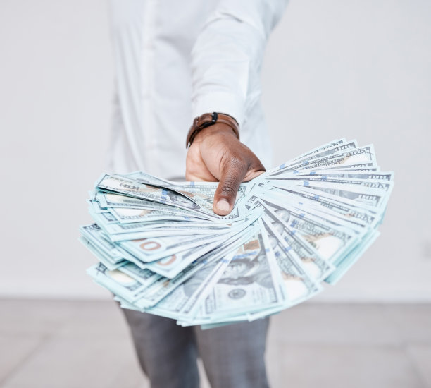 黑人手里拿着美元，钱或现金，付款或商业利润。金融、财富与富人的交易、交换或会计交易、贸易或金融业务交易。图片下载