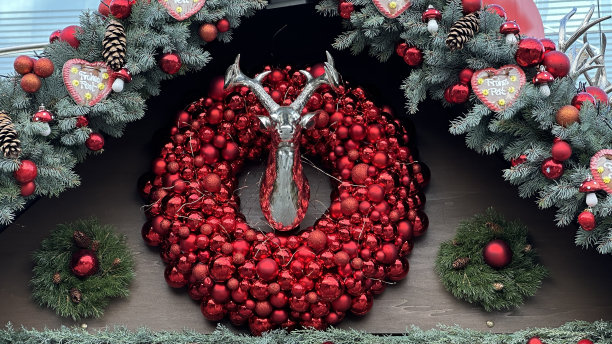 墙上挂着红色的圣诞花环，中间是银色的鹿头图片下载