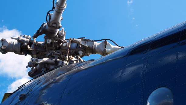 近距离拍摄，深蓝色直升机的主旋翼。蓝天下的蓝色直升机主空气螺旋桨。直升飞机主旋翼上的旋转叶片。飞机的叶片和主旋翼。图片下载