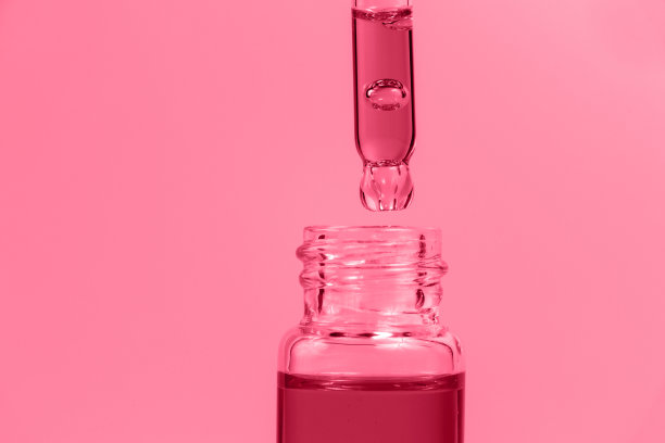 移液管上有一个洋红色背景的玻璃瓶。图片下载