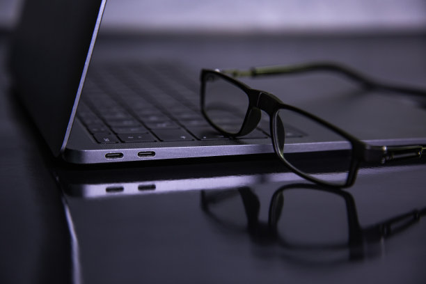 黑色背景的笔记本电脑上的眼镜图片下载