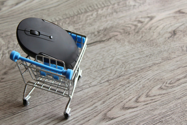 电脑鼠标里面的购物车在木桌上图片下载