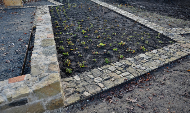 石头路面刚刚铺干，在两个钢板路沿之间的砾石回填中。砂岩和烧过的砖块有一种乡村的感觉。草本花园里狭窄的公园小径，低矮，闭塞，烧焦了图片下载