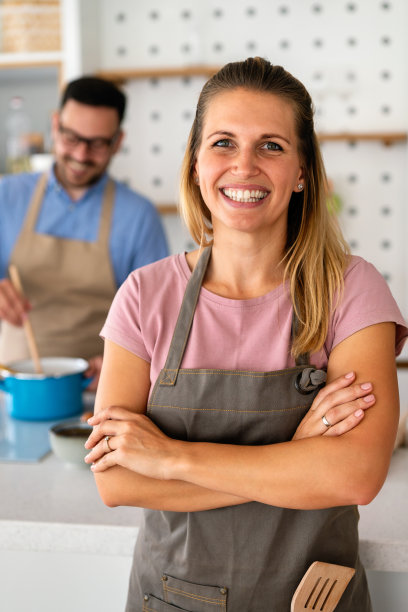 家里的健康食品。快乐的女人正在厨房里准备有机生物餐。图片下载