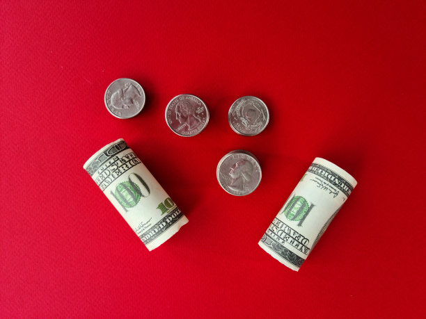 在一堆硬币的背景上折叠的一百美元纸币图片下载