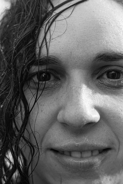 一个微笑的白人妇女在浴室淋浴的垂直镜头图片下载