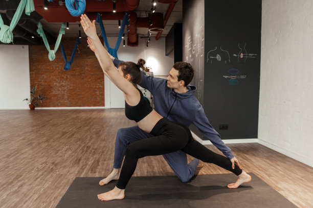 一群年轻人和教练在瑜伽宽敞的工作室练习瑜伽图片下载