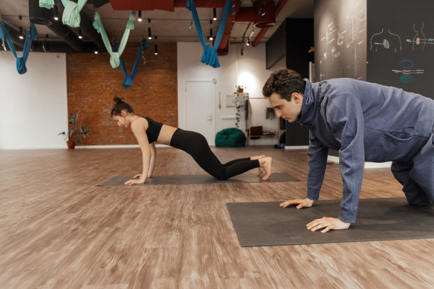 一群年轻人和教练在瑜伽宽敞的工作室练习瑜伽图片下载