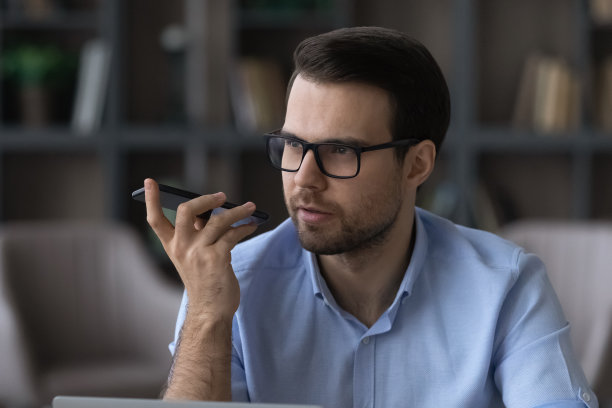 专注的年轻商人用手机录制音频信息。图片下载