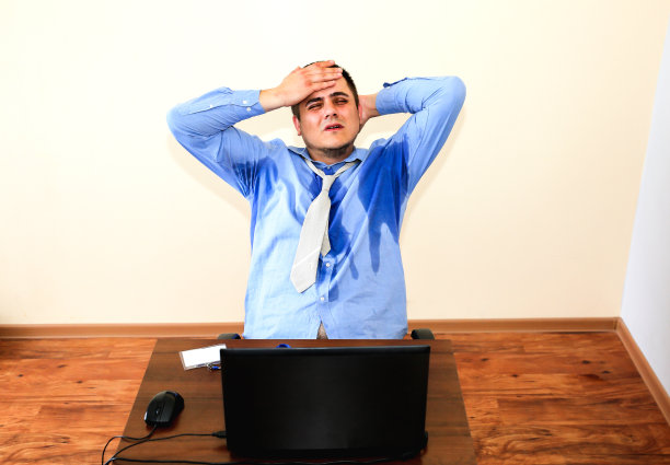 汗流浃背的上班族。湿的衬衫。恶劣的工作条件。不愉快的经理。夏天热。大楼里没有空调。图片下载