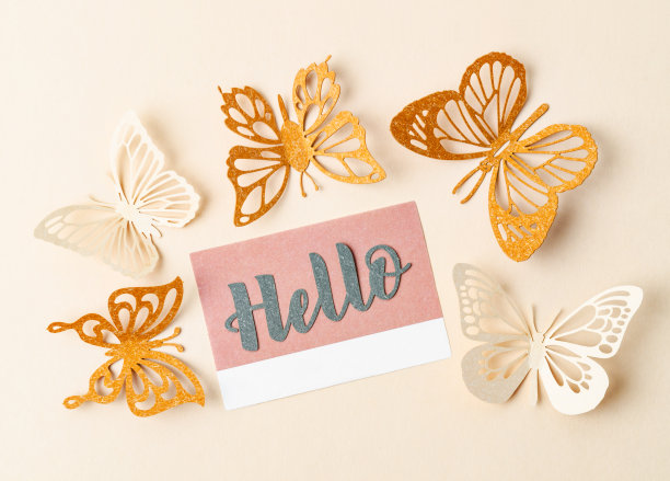 便条纸上的Hello文字和黄色背景上的纸蝴蝶。图片下载