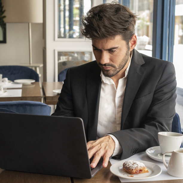 一个商人在咖啡店里用笔记本电脑写东西图片下载