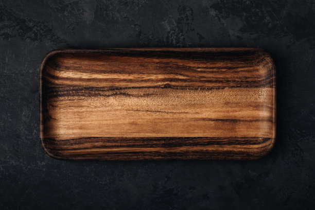 木托盘。木制托盘，板，砧板在深色石材混凝土背景，俯视图。图片下载